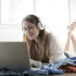 woman in white shirt using silver macbook